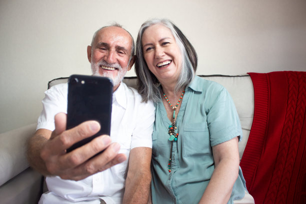 老夫妇拿着手机自拍。图片下载