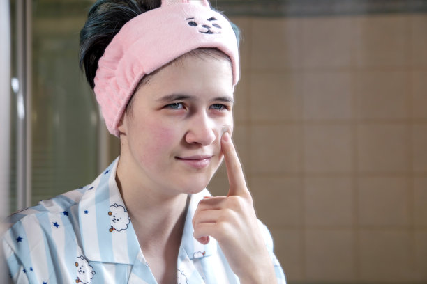 这个女孩在脸上涂了一层润肤霜。护肤，健康生活。图片下载