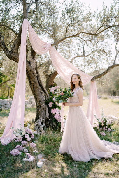 新娘拿着一束花站在树下图片下载