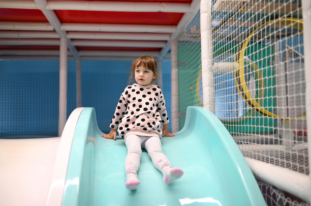 幼童在夏日公园玩耍。宝宝在玩滑梯图片下载