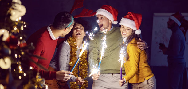 新年和圣诞节庆祝活动。除夕之夜，一群来自不同文化背景的朋友站在办公室里玩得很开心。图片下载