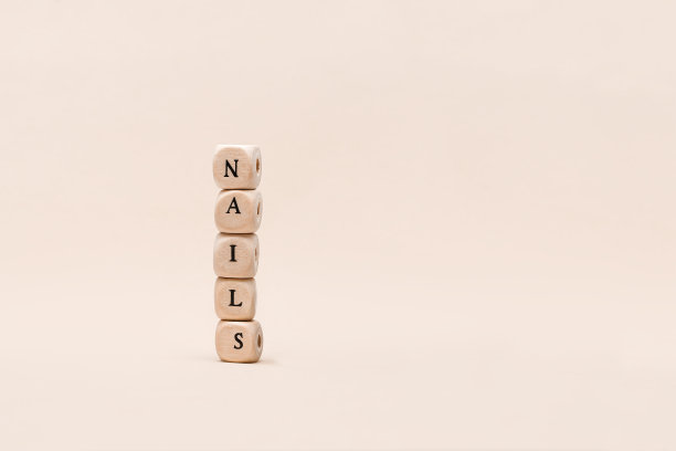 用钉子这个词排列的木块。字钉子从木块在米色的背景。副本的空间。图片下载