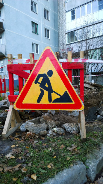 红色及黄色道路工程标志，表示住宅楼宇附近的建筑工程。建筑工地。恢复重建理念。路上的障碍。重建。混乱。在城市道路施工。图片下载