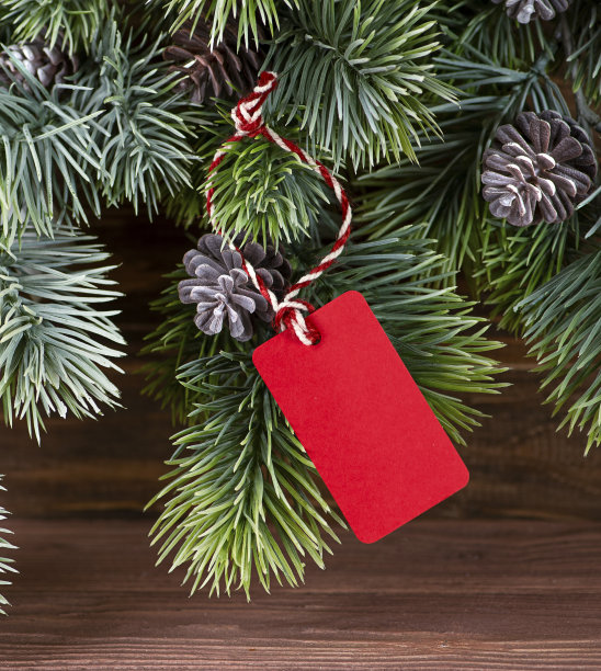 圣诞背景松枝木制背景和红色标签。图片下载