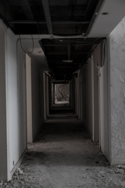 一个废弃建筑里可怕的黑暗走廊。破旧的墙壁。一个废弃的房子里光影的游戏。破碎的门。废弃的旧医院图片下载