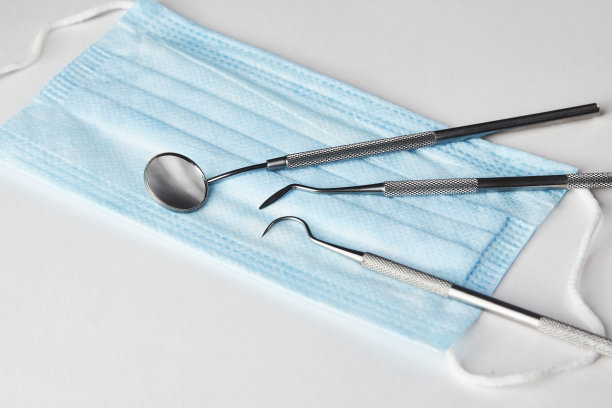 白色背景上的牙科工具和医用口罩图片下载