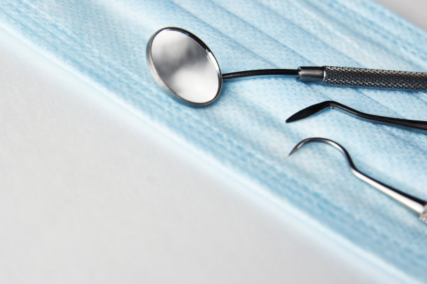 白色背景上的牙科工具和医用口罩图片下载