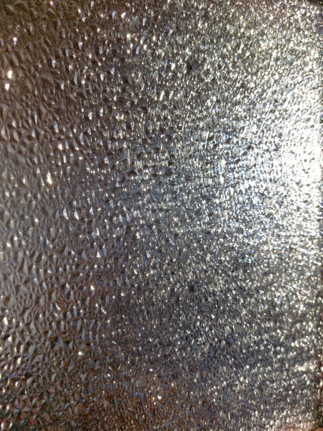 玻璃浮雕表面的照片特写与折射光凹凸不平的纹理背景图片下载