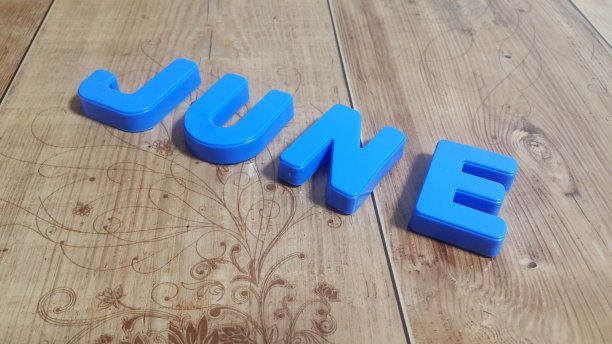 塑料彩色字母“June”被放置在木地板上图片下载
