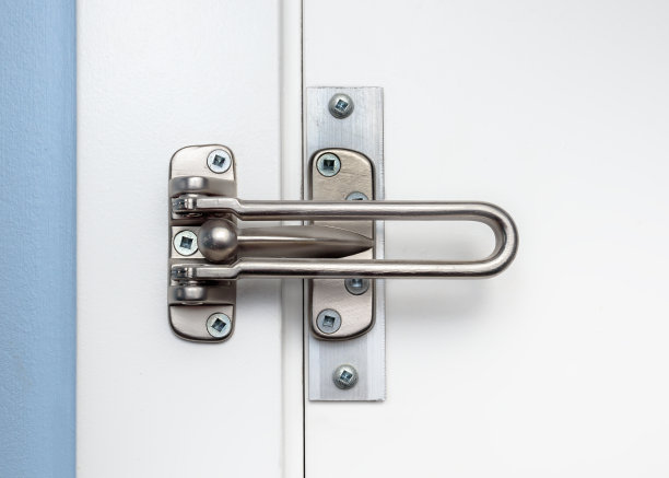 门锁防护安装在白色关闭的门上，前视图。图片下载