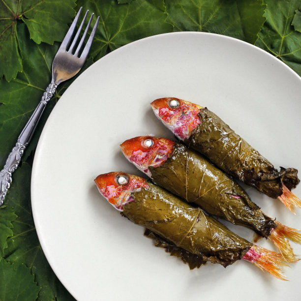用藤叶包裹的红鲻鱼放在盘子上图片下载