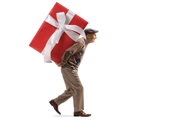 一个老人背着一个大包裹的礼物的全长侧面照片图片下载