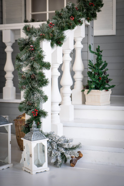 圣诞节的早晨。门廊，一间门上装饰着圣诞花环的小房子。冬天的童话。图片下载