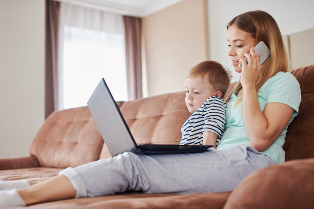 忙碌的母亲在打电话，而她无聊的儿子在附近图片下载