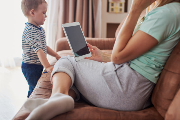 近距离的母亲与平板电脑和她的儿子在家里玩图片下载