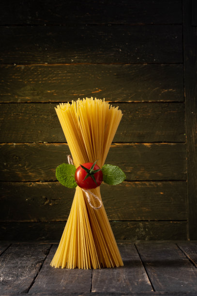 意大利面和圣女果。没有煮熟的意大利面条。意大利面站立。图片下载