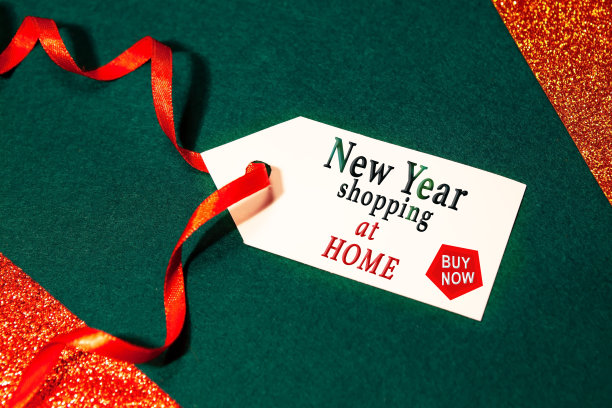 标签上写着:在家过年，现在就买，用红色的丝带，绿色的背景。图片下载