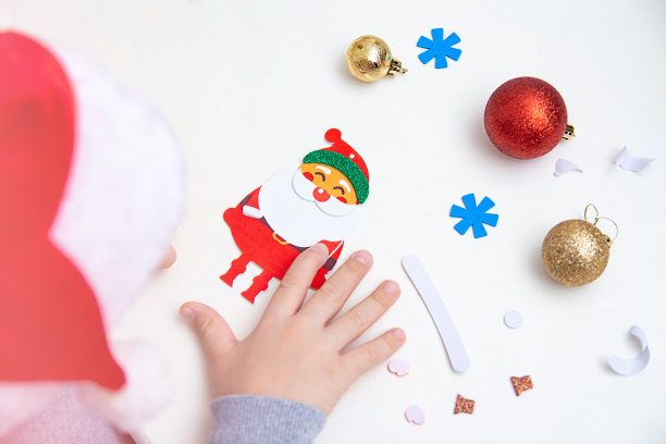 孩子们坐在桌旁做圣诞工艺品。学前教育和早期发展。圣诞节和新年前夜。图片下载