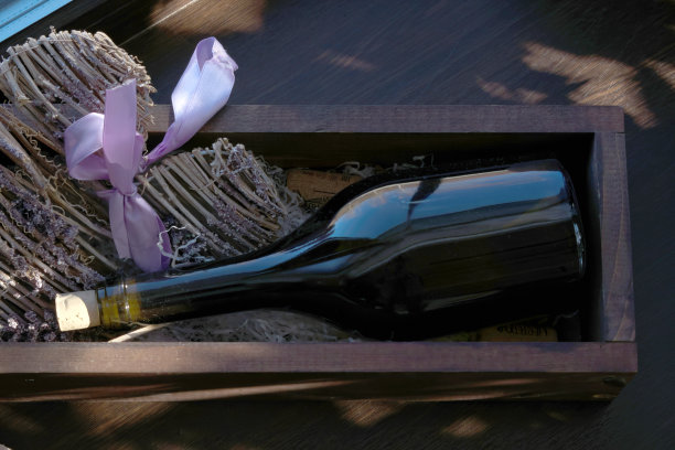 一个木盒子里装着黑色的空酒瓶，一缕阳光落在瓶塞的脖子上图片下载