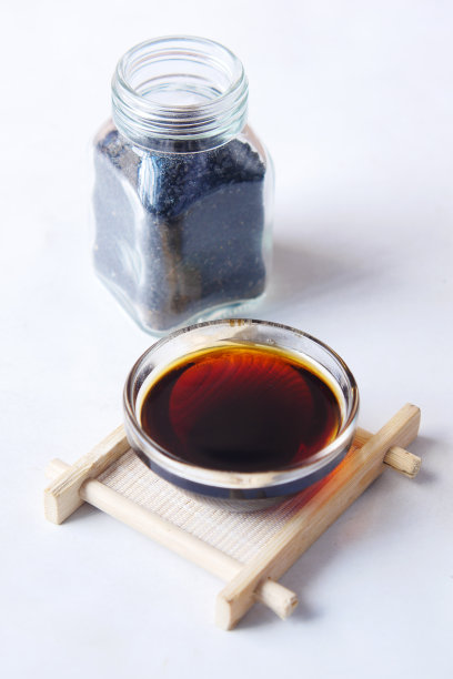 黑孜然油在一个容器在桌子上。图片下载