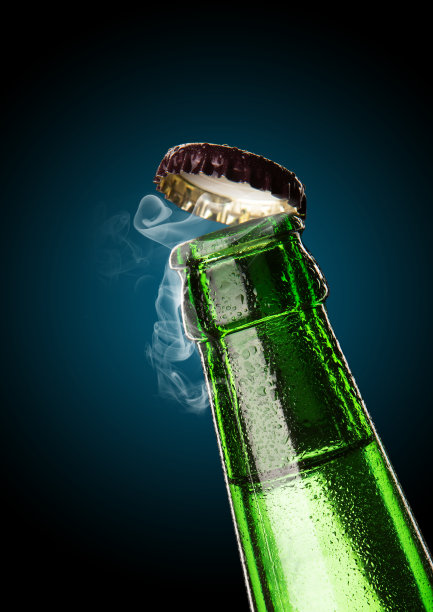 一瓶冰镇的饮料，滴在瓶子里。啤酒瓶盖的开启与气体输出。图片下载