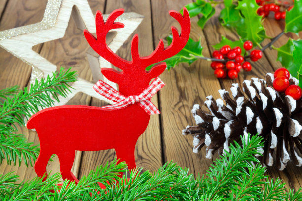 木制圣诞装饰与冷杉枝和红色驯鹿的木制背景图片下载