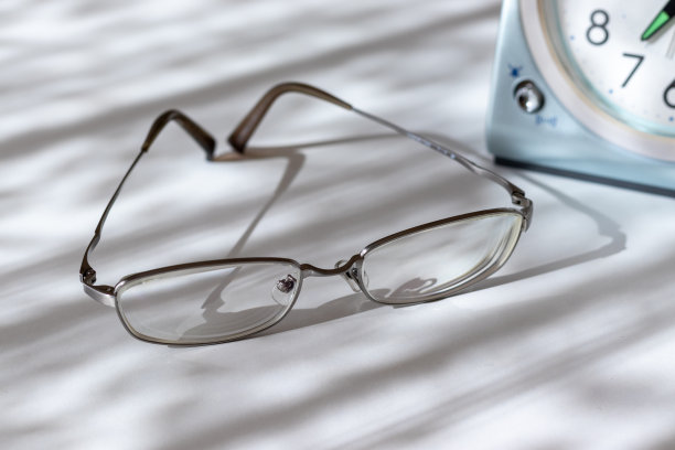 眼镜和表钟放在窗边的桌子上图片下载