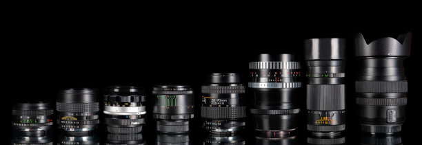 现代和旧的数码单反相机镜头设置在黑色背景与反射图片下载