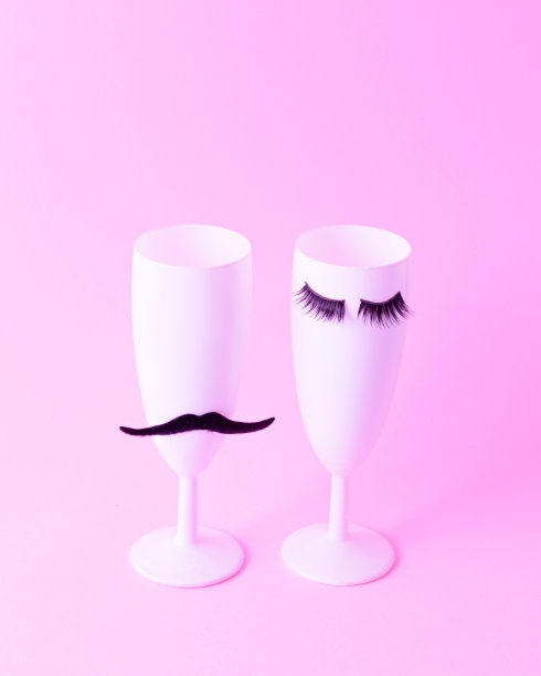 两个白色香槟酒杯。一个有睫毛，一个有胡子。图片下载
