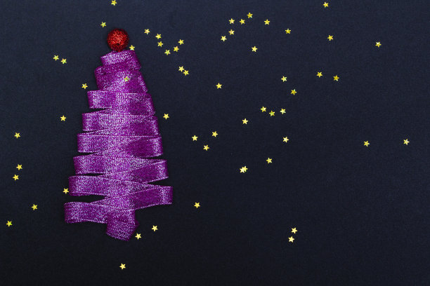 紫色的圣诞树由丝带制成的黑色背景与星星的复制空间。明信片模板，包装。图片下载