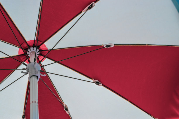 伞的海滩。红色夏日沙滩阳伞在蓝色的大海背景上。度假旅行用遮阳伞。户外休闲度假在海洋与复制空间。图片下载