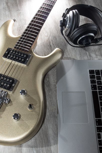 音乐制作。用电吉他、笔记本电脑和耳机谱曲图片下载