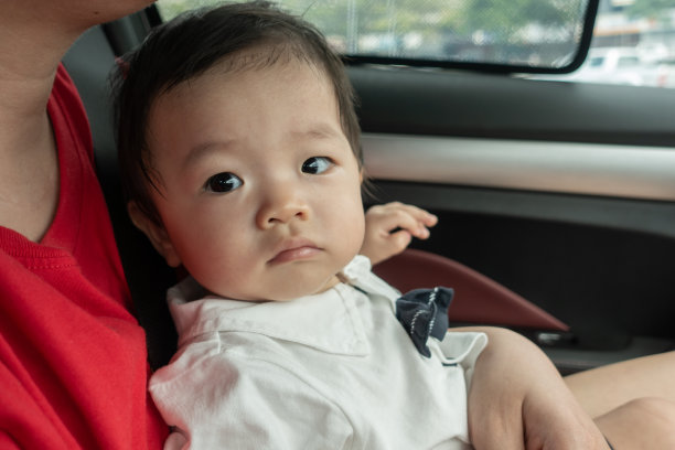 当地生活方式亚洲华人男婴快乐微笑白色坐在儿童安全汽车座椅图片下载