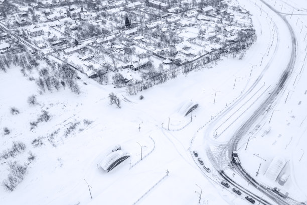 冬季的郊区住宅区有积雪覆盖的房屋和树木。空中无人机的照片。图片下载