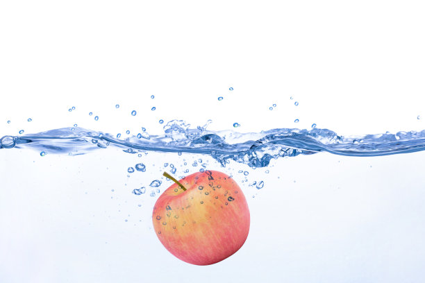 苹果落在蓝色的清水飞溅孤立的白色背景。图片下载