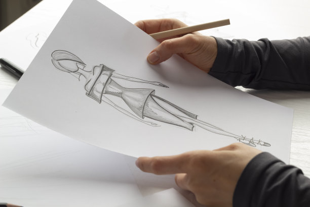 设计师在纸上画女服装的草图。图片下载