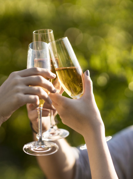 在户外享受时，手与香槟杯的亲密接触图片下载