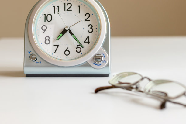 白色的桌子上放着眼镜和时钟图片下载