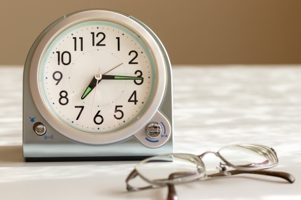 白色的桌子上放着眼镜和时钟图片下载