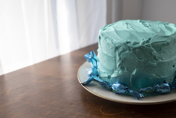 白色盘子上有蓝绿色糖霜的蛋糕图片下载