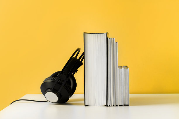 耳机上的书。有声读物水平横幅与copyspace。网络教育和网络学习的概念图片下载