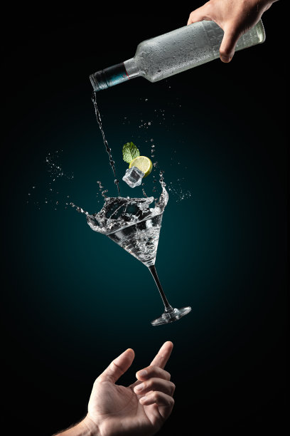 男子的手支持飞杯鸡尾酒饮料与飞溅在深蓝色的背景。重力的概念。图片下载