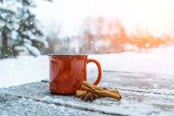 森林雪景中木制背景上的热红酒或茶图片下载