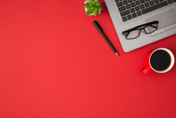 顶视图照片的眼镜上的笔记本电脑花盆钢笔和红色杯子上的饮料孤立的红色背景与copyspace图片下载