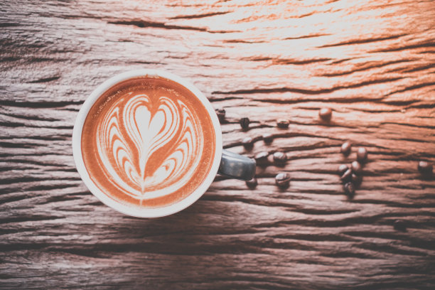 咖啡拿铁艺术烘焙咖啡豆平放在木桌上，放松时间，咖啡师艺术顶视图。图片下载