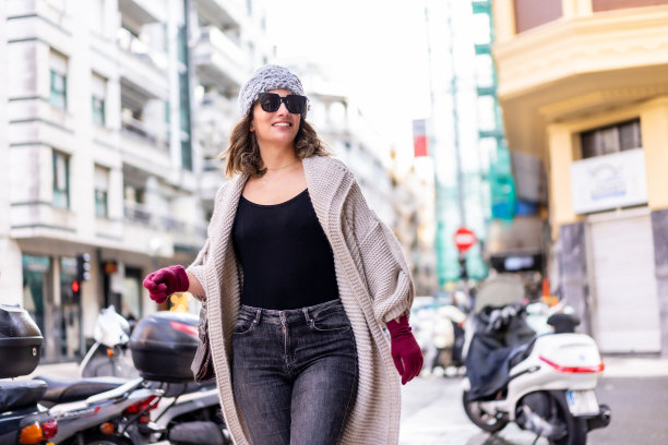 生活方式，年轻的白人金发女孩享受和微笑在城市的冬天。戴着墨镜和红色手套散步图片下载