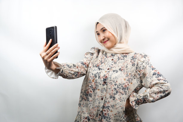 美丽的年轻亚洲穆斯林女商人开朗，自信和热情，自拍，孤立的白色背景图片下载