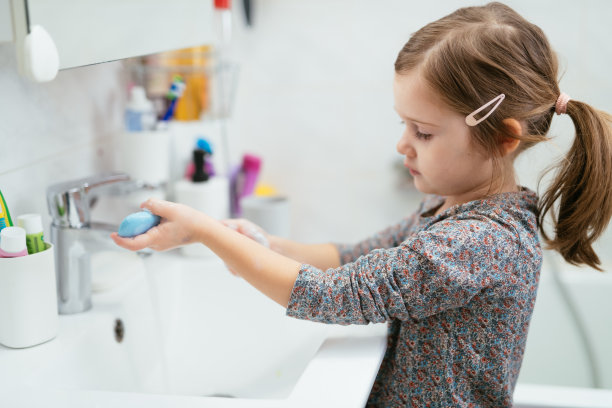 四岁的女孩在浴室里，用肥皂洗手和洗脸图片下载