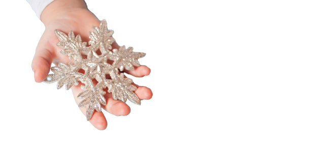 女孩的手捧着圣诞装饰的大雪花，一双手放在蓝色的背景上。文本的空白位置。图片下载