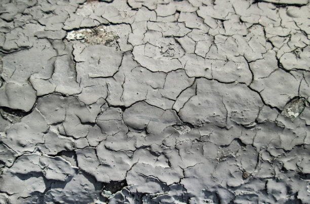 白色表面上的深深的裂缝。旧涂层的效果。图片下载